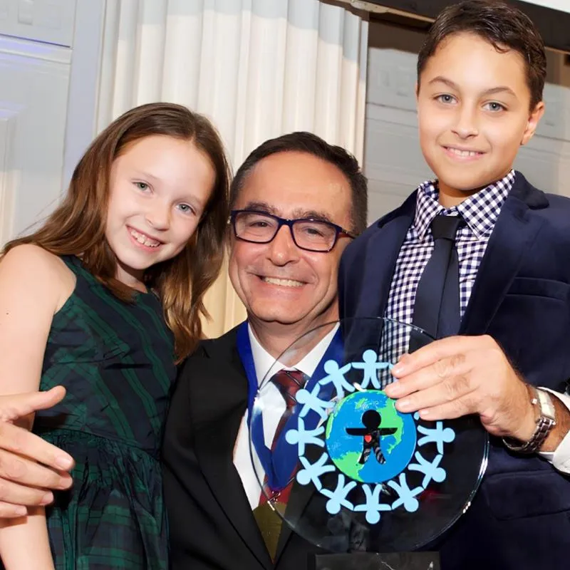 Dr. Üstün Ezer, 2017 World of Children Health Award töreninde iki çocukla birlikte ödülü tutarak uluslararası başarıyı paylaşıyor.